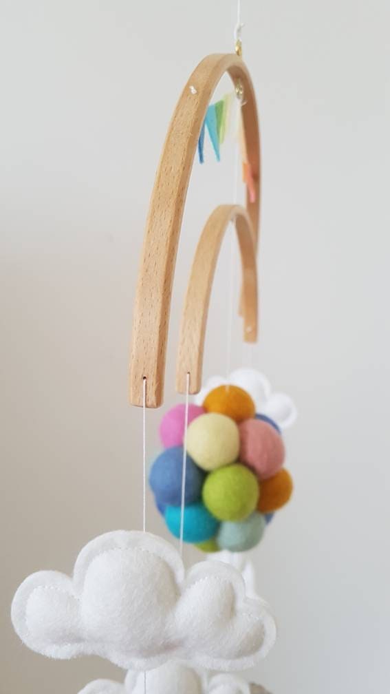 Teddy bear flying with pastel rainbow balloons